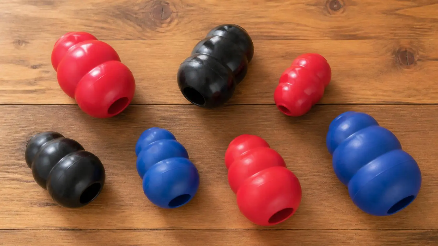 A collection of different Kong dog toys including the Classic, Wobbler, and Extreme lined up together